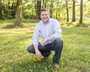 Dr. Strandburg smiling and posing in the woods