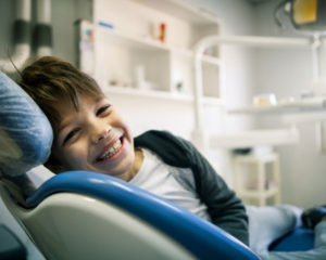 young kid smiling in dentist chair
