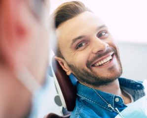 young man smiles at dentist
