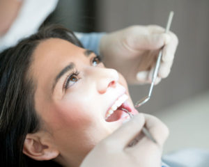 a young woman gets her teeth cleaned at a dental clinic