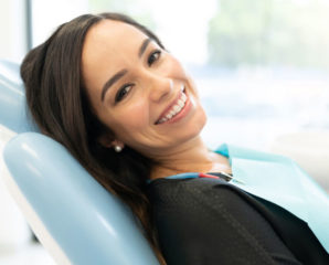 a smiling female dental patient in the chair