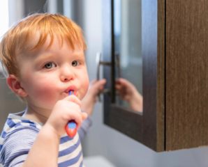 kid is brushing his teeth