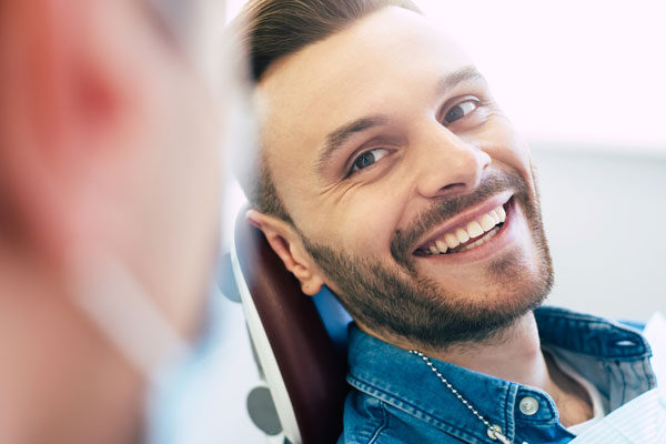 young man smiles at dentist