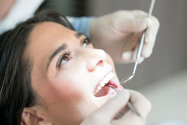 a young woman gets her teeth cleaned at a dental clinic