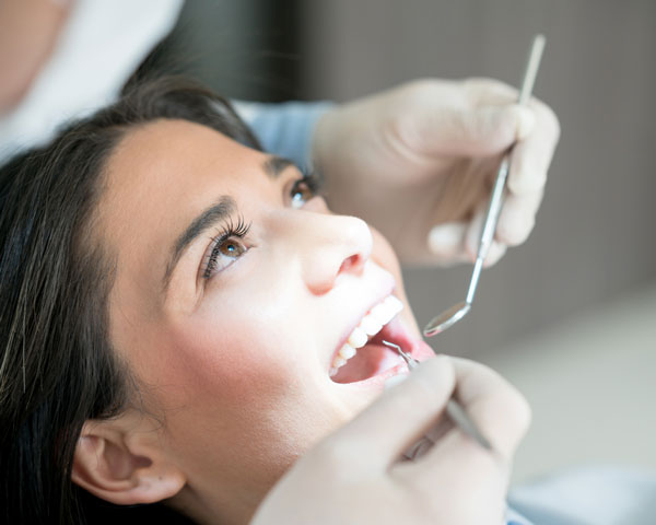 a young woman gets her teeth cleaned at a dental clinic