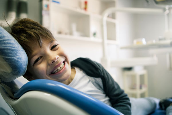 young kid smiling in dentist chair